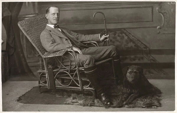 Man in wickerwork chair with pet dog