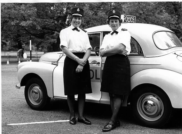 Two women police officers standing by a car, London