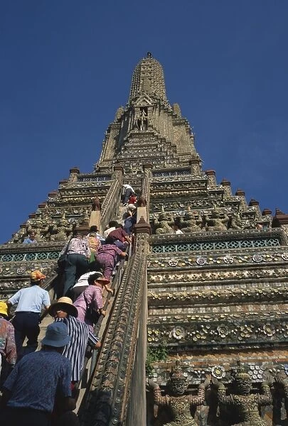 Tourists climb the steps of Wat Arun (Temple of the Dawn)