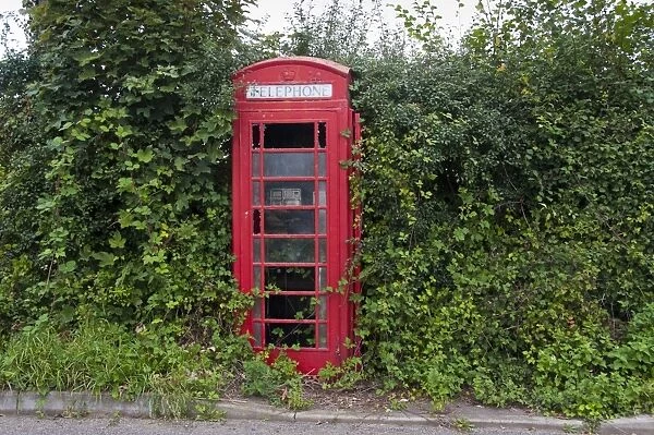 Disused and vandalised red telephone box in rural location, Wattisfield, Suffolk, England, august