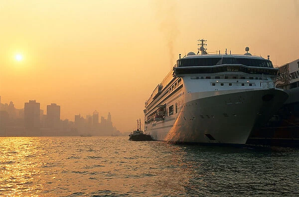Cruise ship docked at Ocean Terminal at sunset, with Hong Kong Island in background