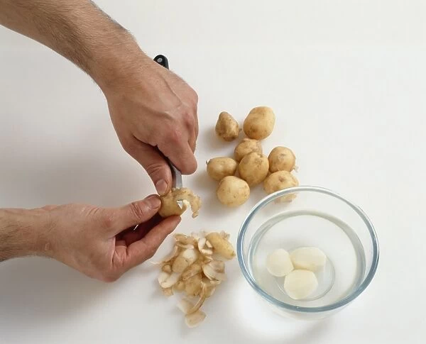 Man using small kitchen knife to peel new potatoes next to peeled potatoes in bowl of water