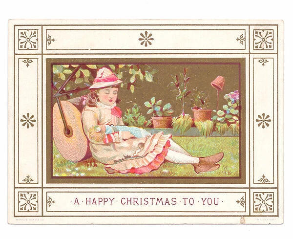 A Victorian Christmas card of a girl sitting on the grass against a lawn roller with a