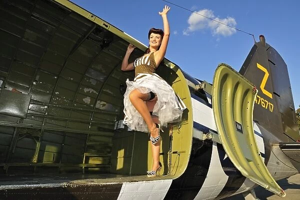 Sexy 1940s style pin-up girl standing inside of a C-47 Skytrain aircraft