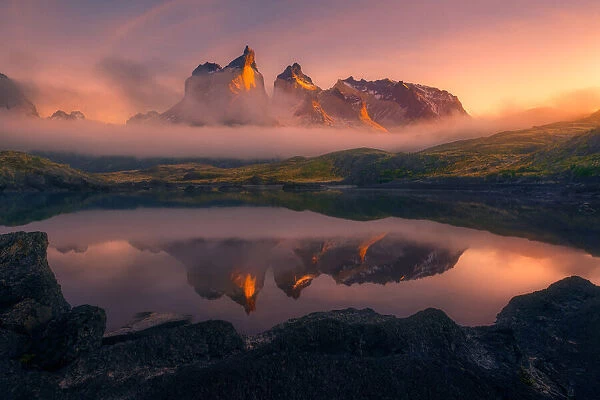 Eternity. Los Cuernos del Paine peaks through low clouds illuminated by