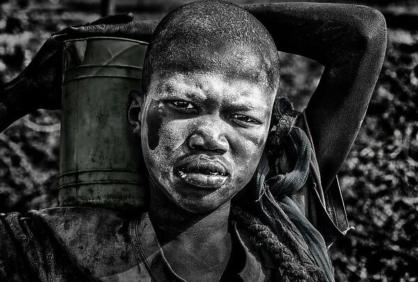 Mundari child carrying a container with milk - South Sudan