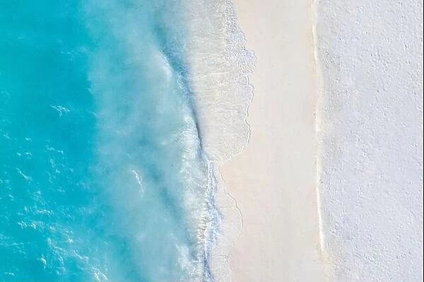 Aerial view of sandy beach and ocean with waves. Beautiful tropical white empty beach and sea waves seen from above. Beautiful sea landscape beach