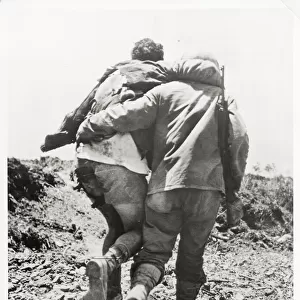 World War II US soldier helped towards the rear