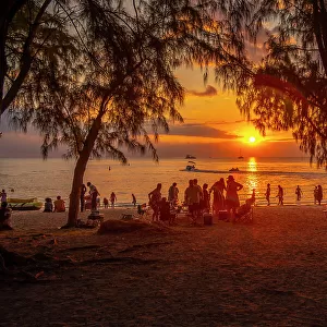 View of people on Mon Choisy Public Beach at sunset, Mauritius, Indian Ocean, Africa