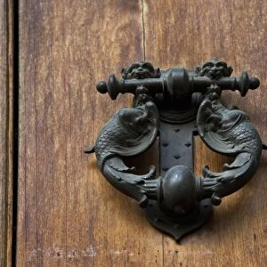 Sienna, Tuscany, Italy - Closeup of ornate, metal door knocker on a wooden door
