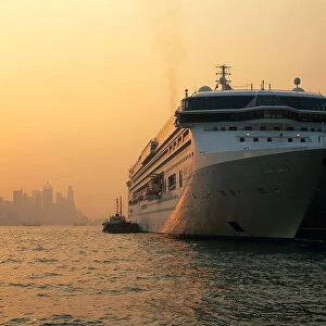 Cruise ship docked at Ocean Terminal at sunset, with Hong Kong Island in background