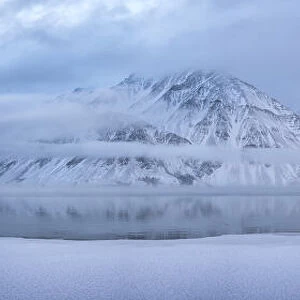 Snow covered Mount Worthington reflected in Kathleen Lake in winter, Haines Junction, Yukon